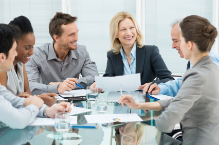 A group of business men and women around a table having a meeting.