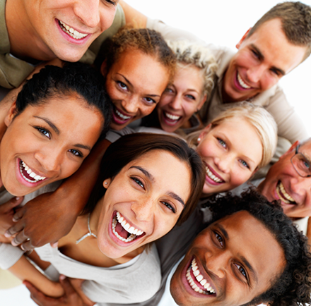 Happy employees in a group looking up and grinning.